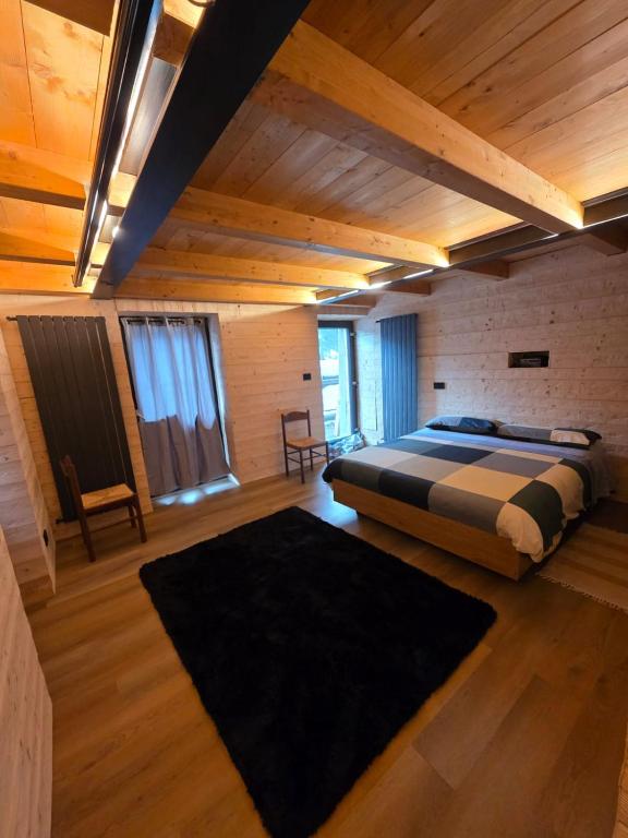 a bedroom with a bed in a room with wooden ceilings at Muranche Loft S1 in Valtournenche