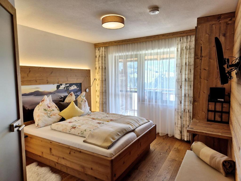 a bedroom with a bed and a large window at Seyerlehnerhof in Maria Neustift