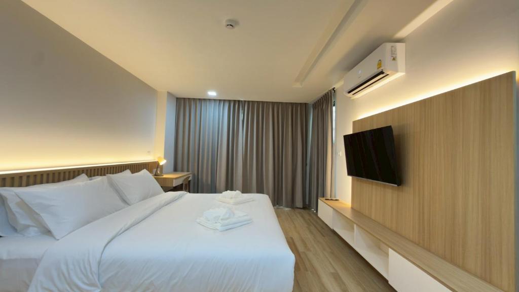 a hotel room with a bed and a tv at Armass Residence in Bangna