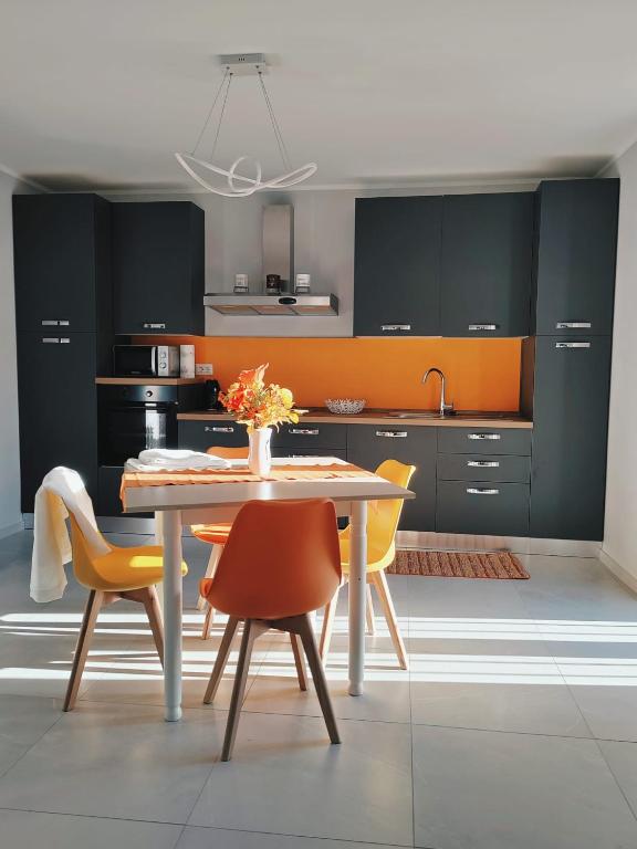 a kitchen with a table and some yellow chairs at Casa Sole in Cannobio