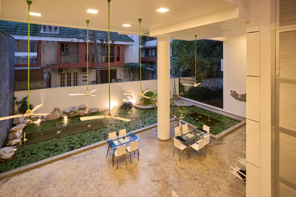 an indoor courtyard with a pond and tables and chairs at Urban Opulence in Bangalore
