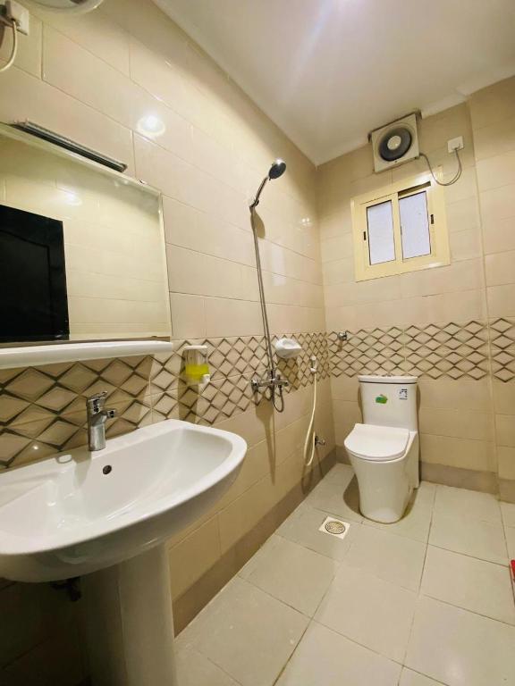 a bathroom with a sink and a toilet at Emaar million6 in Quai