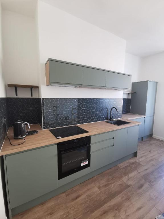 a kitchen with a sink and a stove top oven at Victoria Guest Apartment in Ramsgate