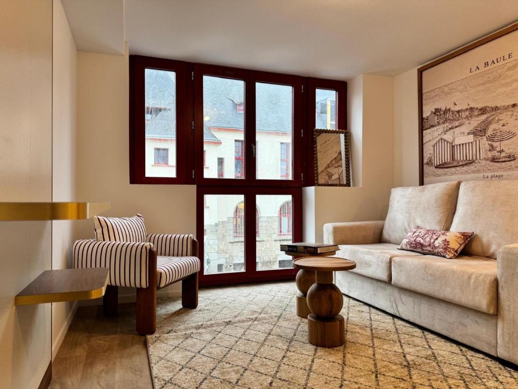 a living room with a couch and a chair at Adonis Collection La Baule in La Baule