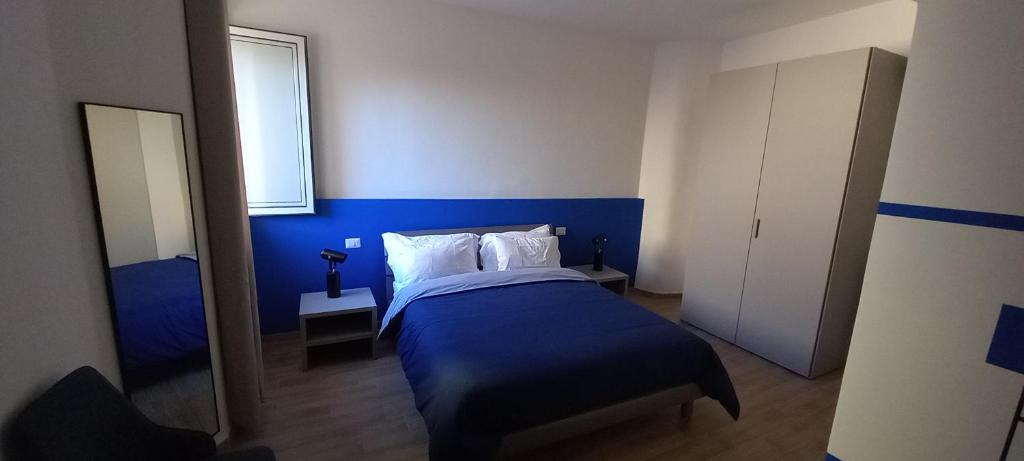 a blue bedroom with a bed and a window at Il Palazzetto in Velletri