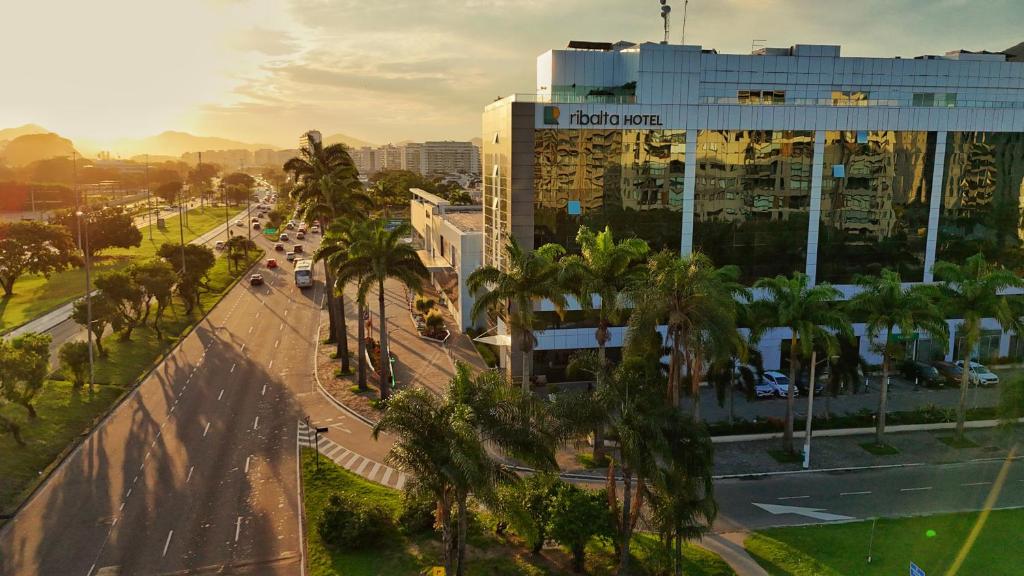 a city street with palm trees and a building at Ribalta Hotel Barra da Tijuca by Atlantica in Rio de Janeiro