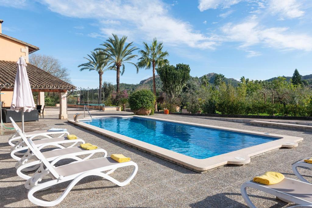 a swimming pool with lounge chairs next to a house at Luxury Villa Es Molinet in Alcudia