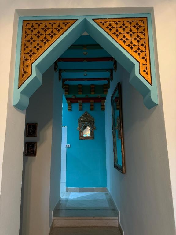 a hallway in a building with a blue wall at Milles et une Nuits Sidi Bou in Dar Salah Bey