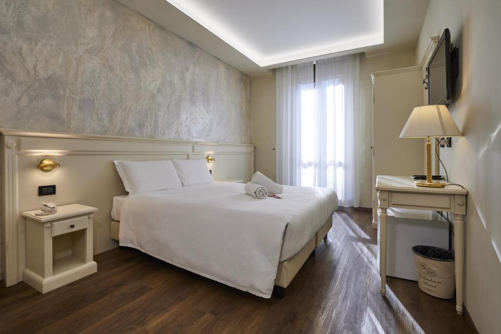 a hotel room with a white bed and a window at Hotel Galimberti in Turin