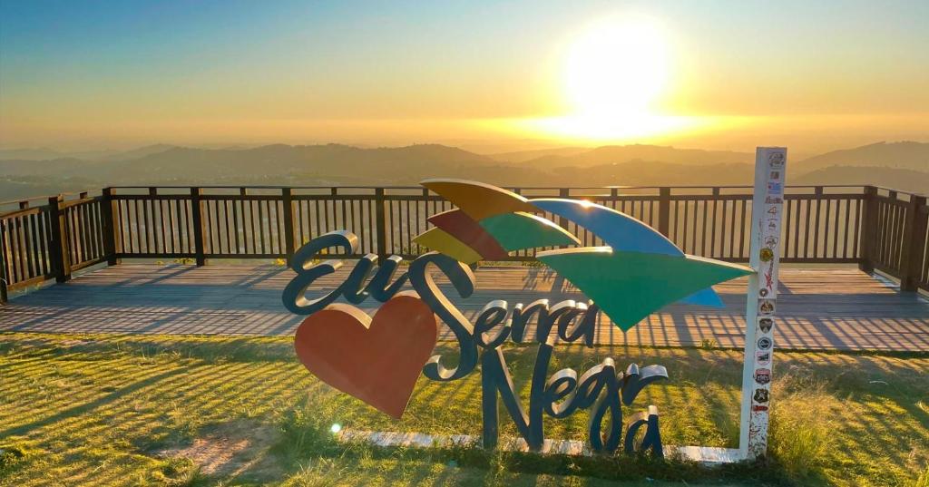 a sign that says love and peace with the sunset in the background at Della Vegas Economy in Serra Negra