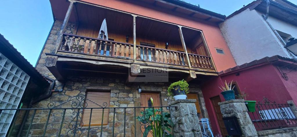 a building with a balcony on the side of it at La Casona y El Apartamento De La Foz in Lugar de Arriba
