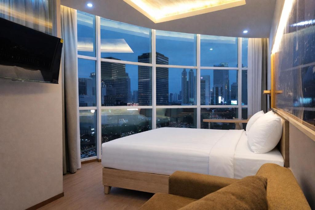a hotel room with a bed and a large window at Smart Hotel Thamrin Jakarta in Jakarta