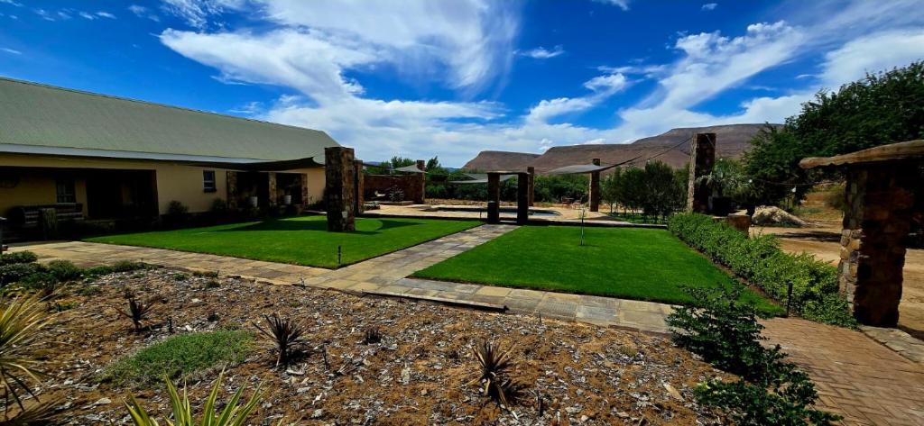 ein Haus mit einem Garten mit grünem Rasen in der Unterkunft Blomberg in Clanwilliam