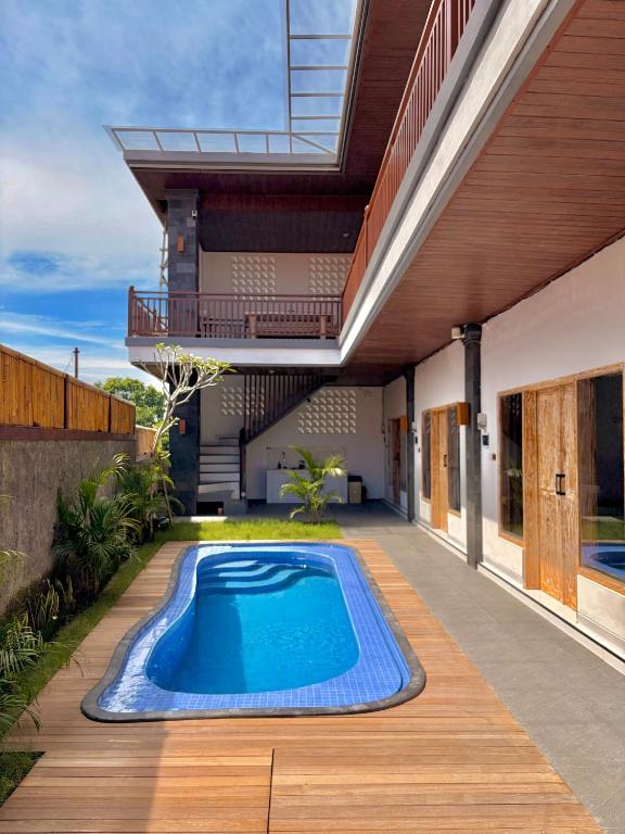 a swimming pool on a deck next to a house at Tanhana Seminyak in Kerobokan