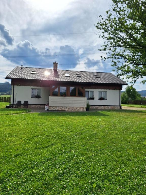 a house in a field with a green yard at Vila pod Dubem in Návsí u Jablunkova