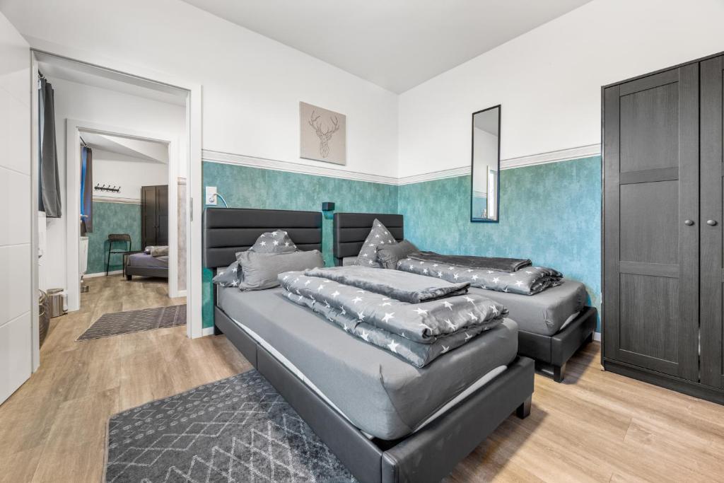 a bedroom with two beds and a blue wall at Heide Ferienwohnung Nord Nr-1 in Schneverdingen