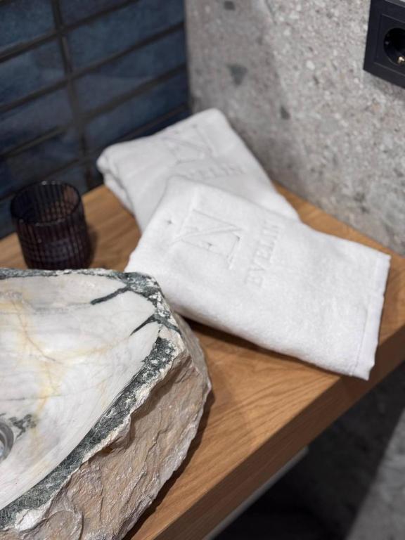 a wooden table with two white napkins on it at Evelin in Maidan Village