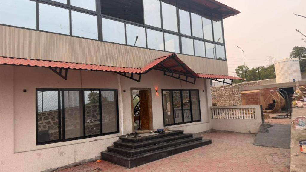 a building with steps in front of a building at The Sixth Abode Farms 5 BHK Villa with Swimming Pool, Turf, Lawn & Indoor Games- Khopoli in Jambhulpāda