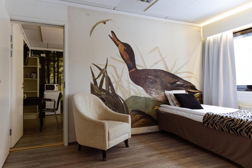 a bedroom with a large mural of a bird on the wall at Hotel Sorsanpesä in Seinäjoki