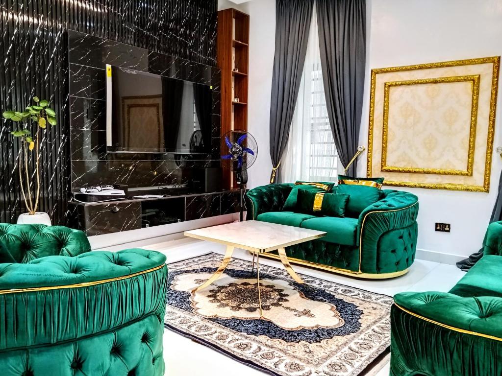 a living room with two green couches and a table at Aquamarine Premium 5 Bedroom Duplex in Lagos in Lekki