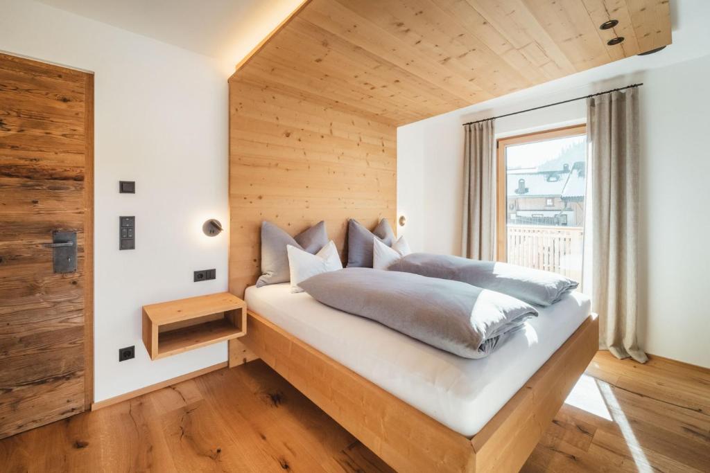 a bedroom with a bed with a wooden wall at Kuenzerhof Apartments in Braies