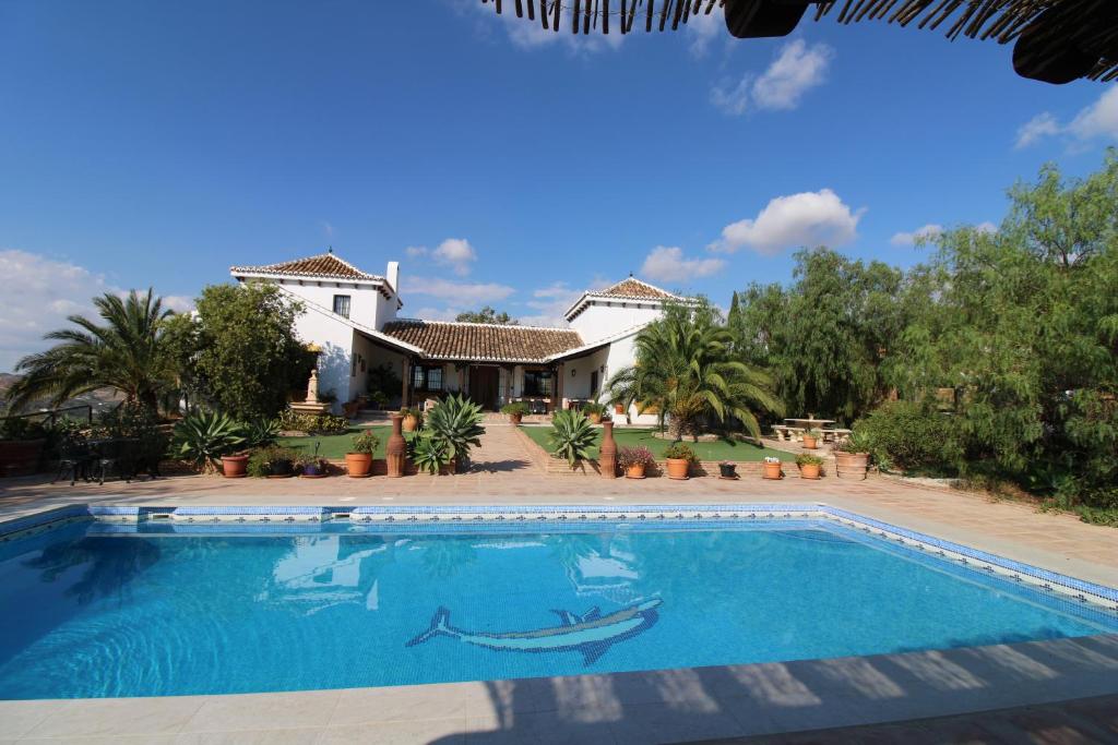 a swimming pool in front of a house at Loma la Parra in Valle de Abdalagís