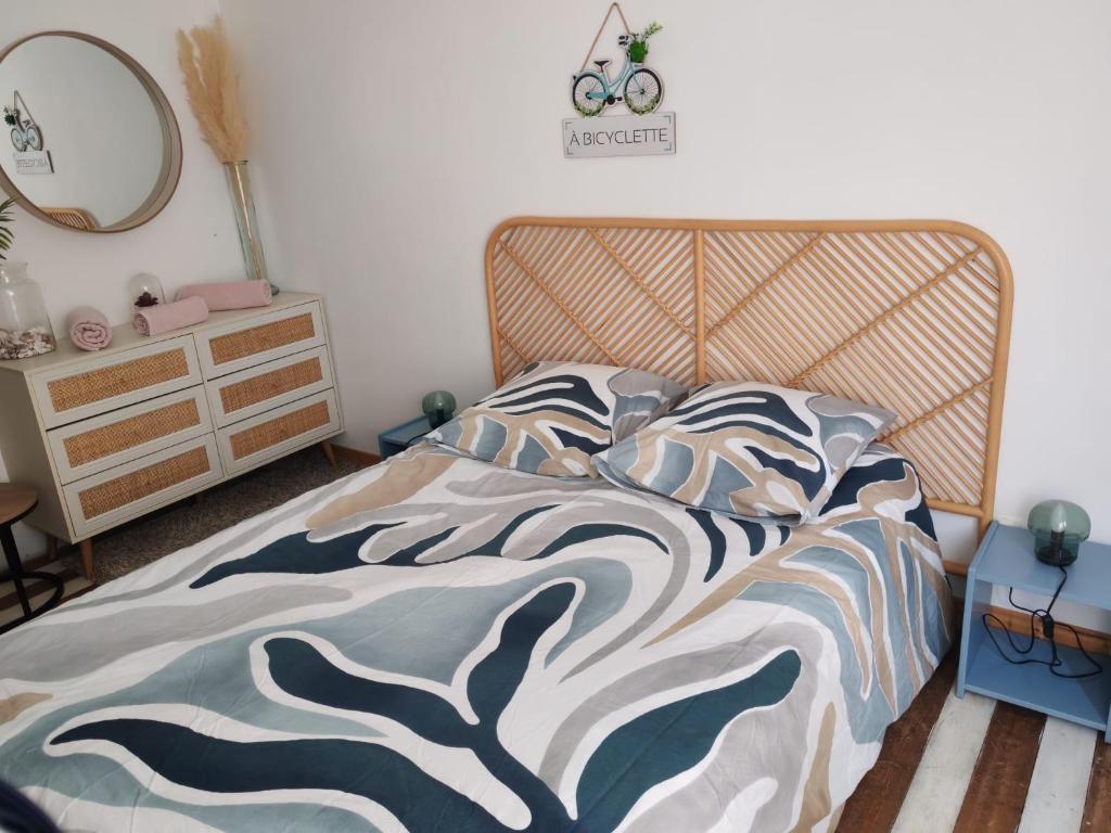 a bedroom with a bed with a wooden headboard at Cabine de la plage 2 in Fécamp