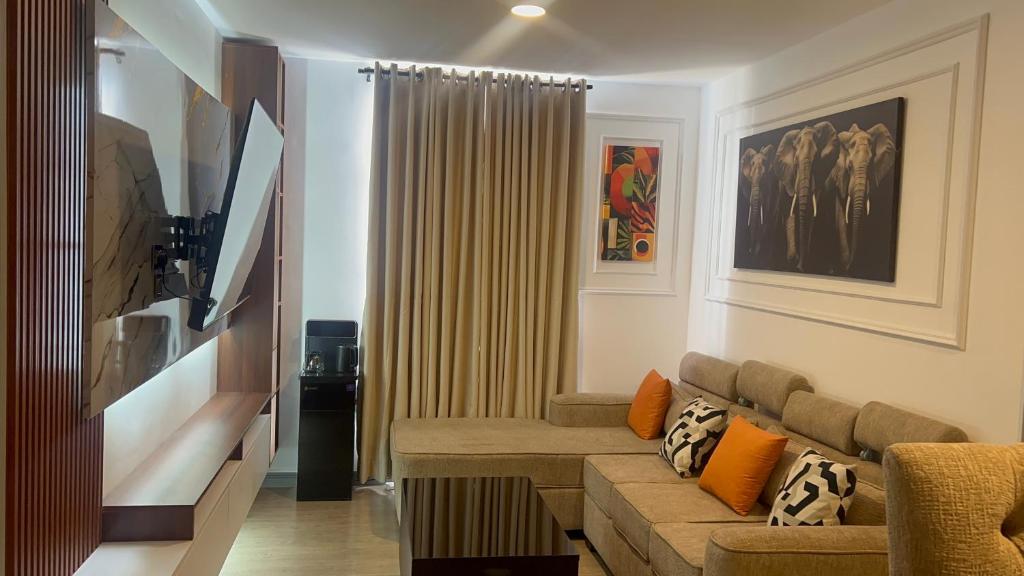 a living room with a couch and a flat screen tv at Upendo Apartment 2 Bedroom in Tilisi in Gatimu