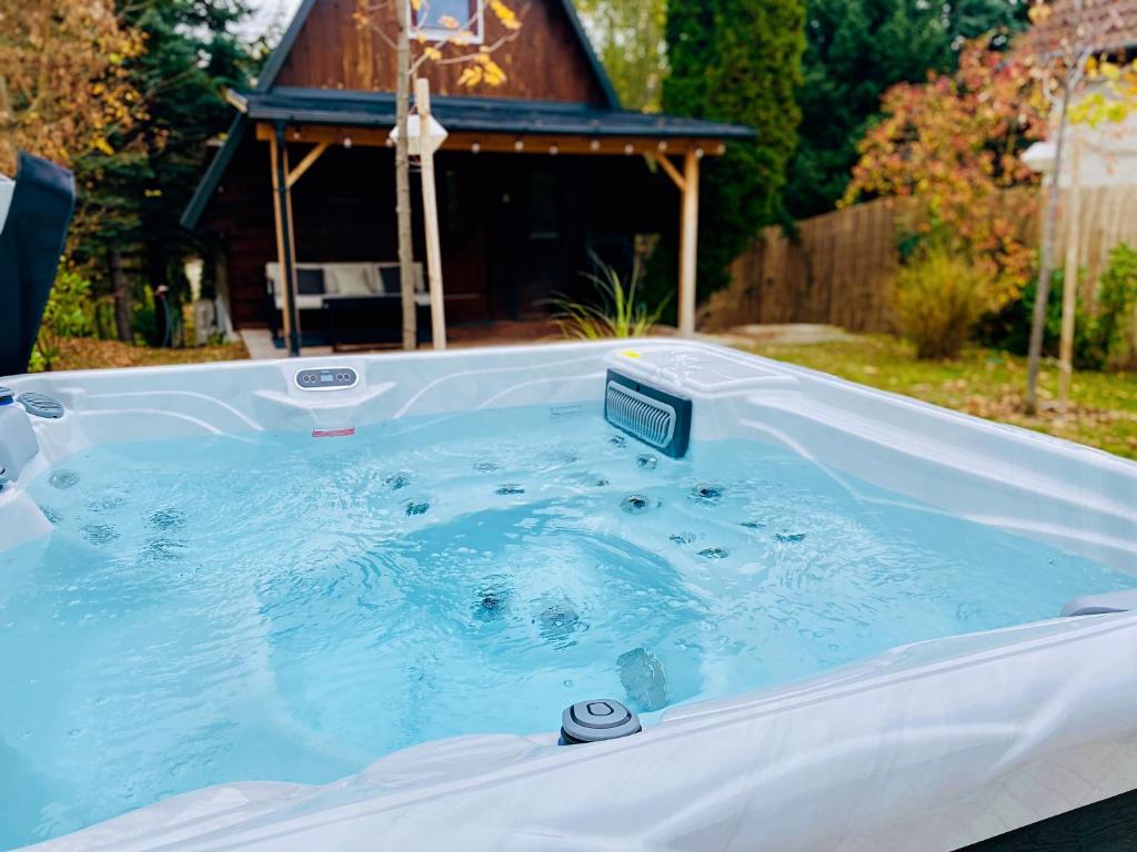 a hot tub in a backyard with a gazebo at Rigó Ház - Kisoroszi in Kisoroszi