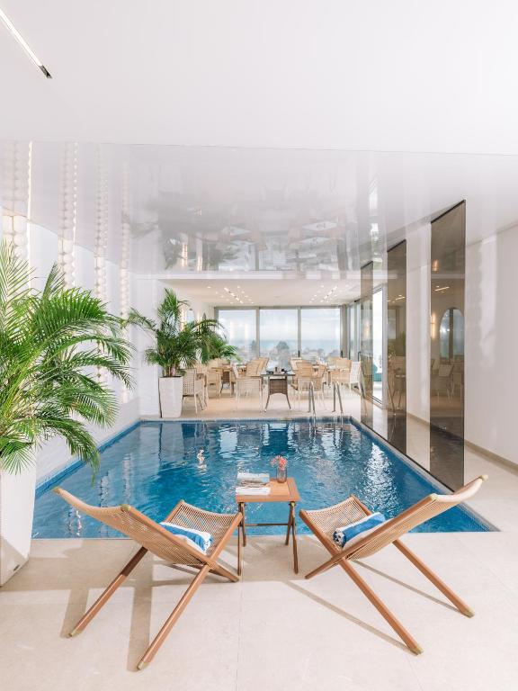 a pool with two chairs and a table in a house at Senator Lux in Ulcinj