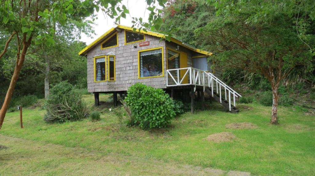 una casita en medio de un campo en Caulín Lodge, en Chacao