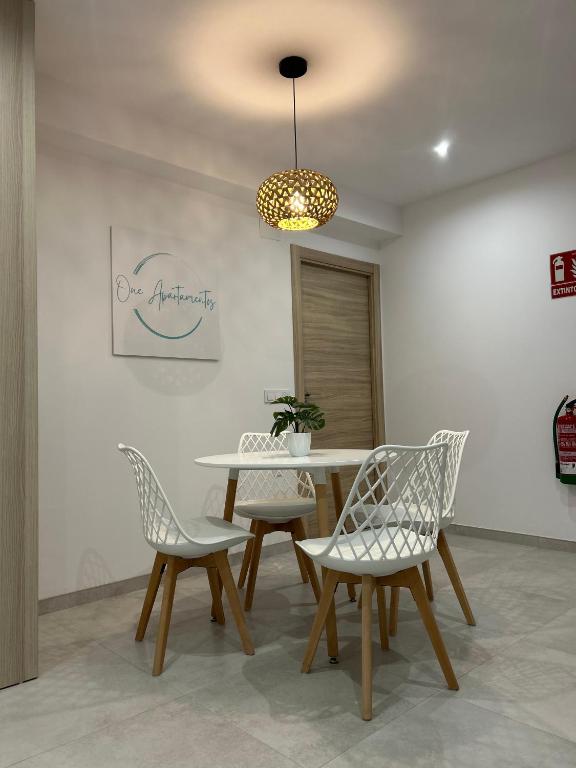 a dining room with a table and two chairs at One Apartamentos in Torreorgaz
