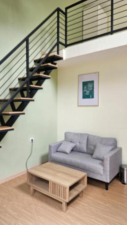 a living room with a couch and a staircase at Abagta Kosan in Jakarta