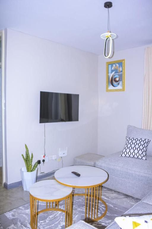 a living room with a couch and a table at TanuStays - Modern 1 Bedroom at Royal Suburbs Tsavo, near TRM in Nairobi