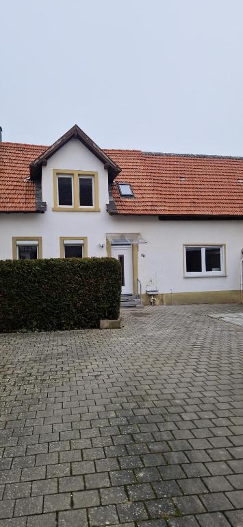 a white house with a hedge in front of it at Privatpension Dreger in Alzey