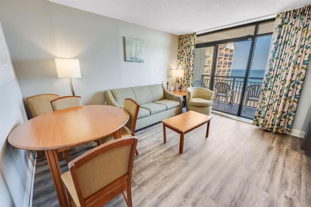 a living room with a couch and a table at New Beachfront, Condo Simply Amazing Pools & Views in Myrtle Beach
