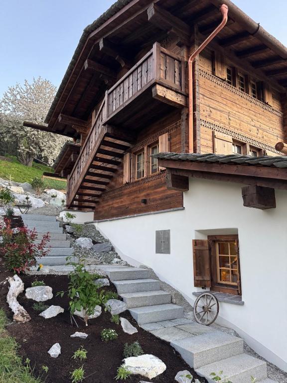 a house with stairs leading up to a building at Chalet Flond in Obersaxen