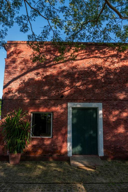 a brick building with a door and a window at La estancia Yapeyú in Yapeyú