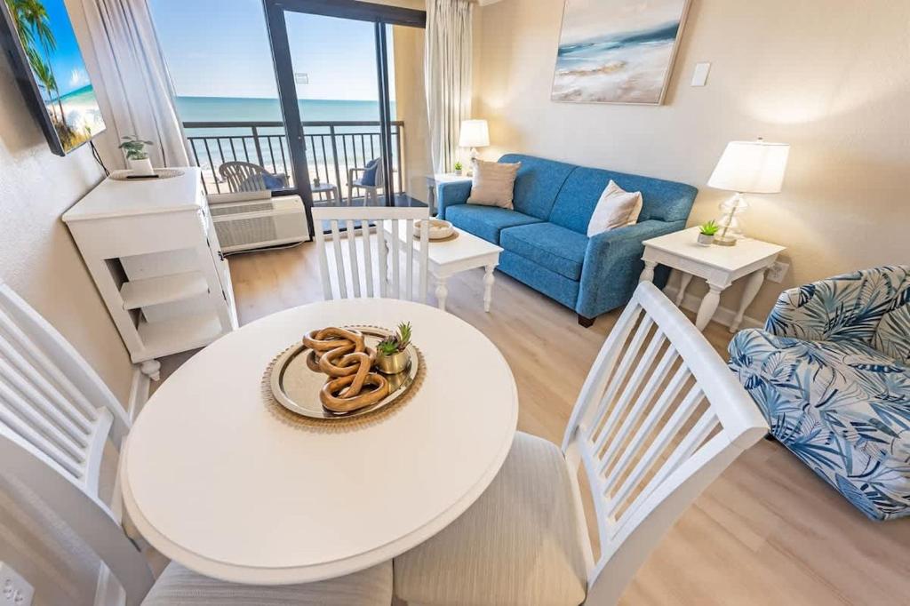 a living room with a white table and a couch at Direct Ocean Front, The Pavilion, Pools, Boardwalk in Myrtle Beach