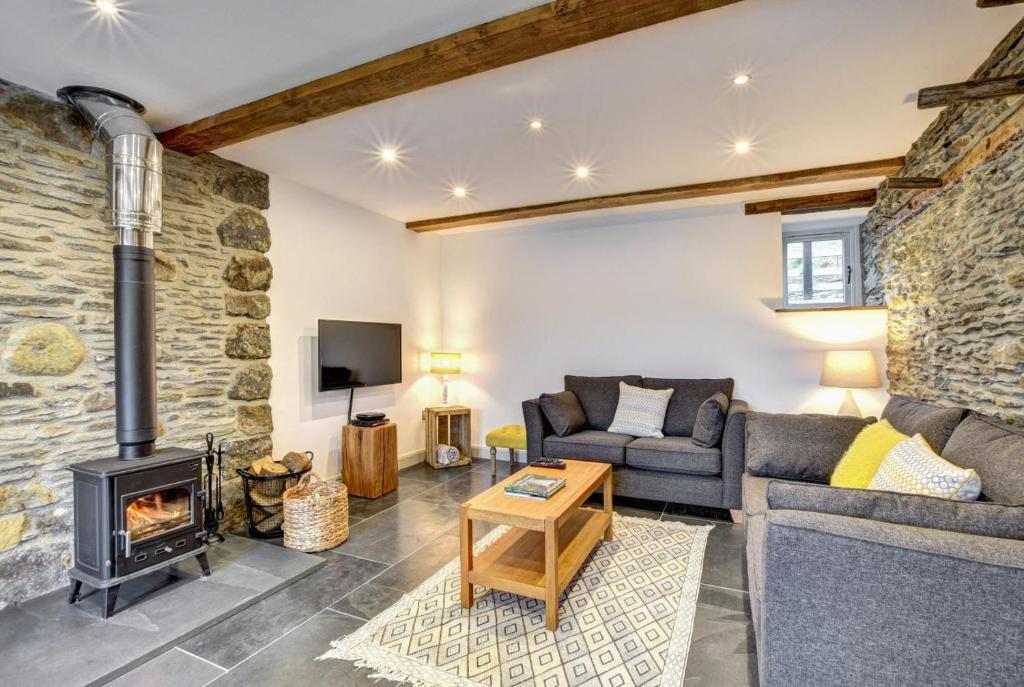 a living room with a couch and a fireplace at 5 Bed in Machynlleth oc-bow30 in Darowen