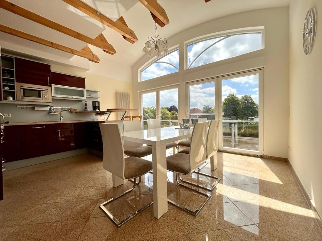 a kitchen with a table and chairs and a large window at Cliner Blick in Wittmund