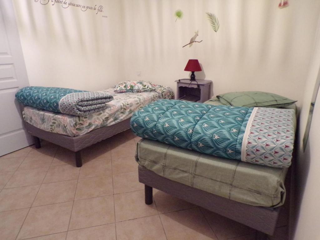 a room with two beds and a table with a lamp at La Grange in Dieulivol
