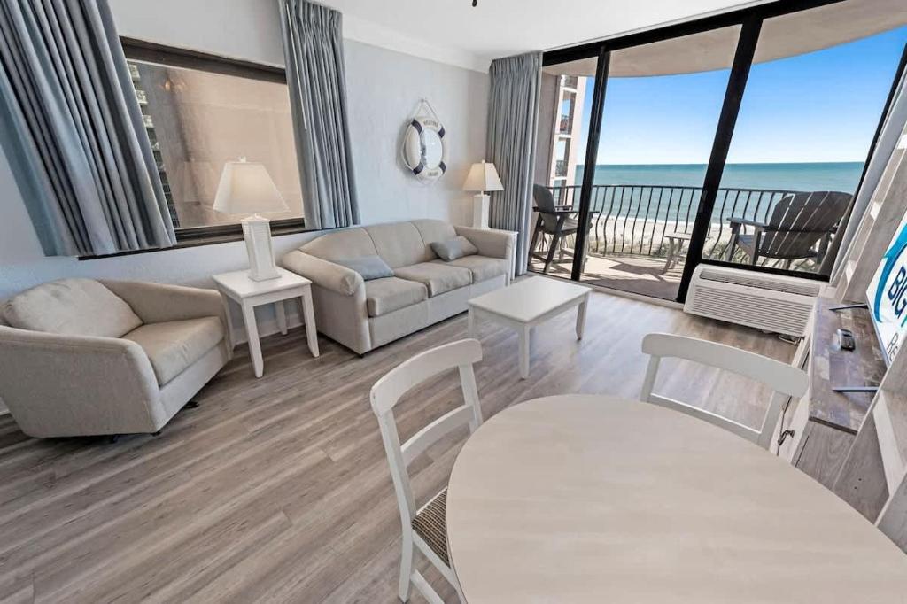 a living room with a couch and a view of the ocean at 1BR Direct Oceanfront Views at Palms - Nice Pools! in Myrtle Beach