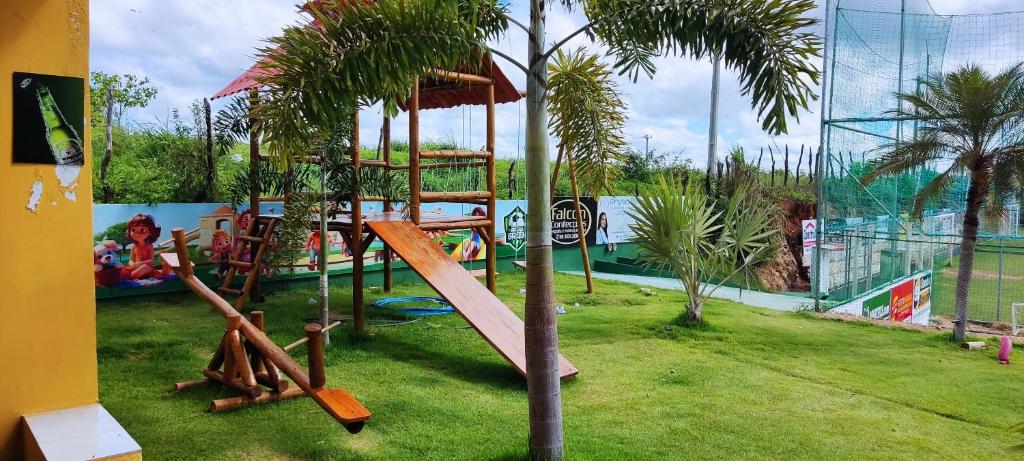 a playground with a slide and a tree at Hotel Fazenda Arena Green in Cajazeiras