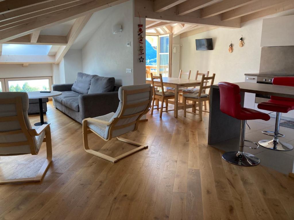 a living room with a couch and a table and chairs at Respiro di lago in Molveno