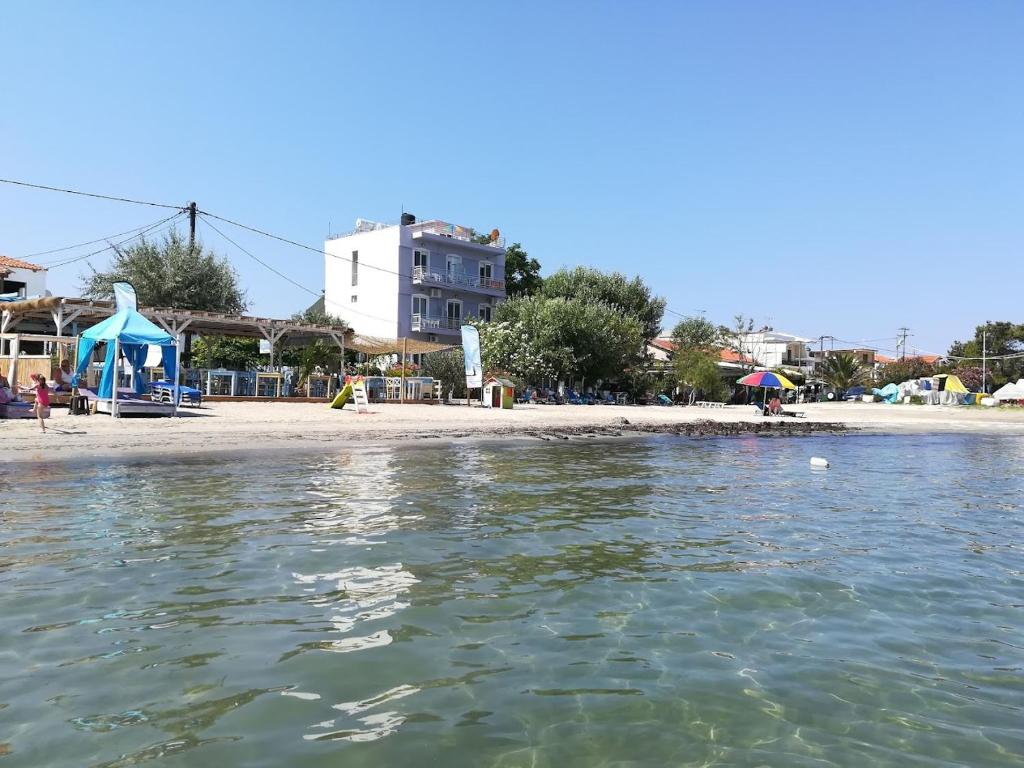 a beach with a house and the water at Hotel Prinos in Skala Prinou
