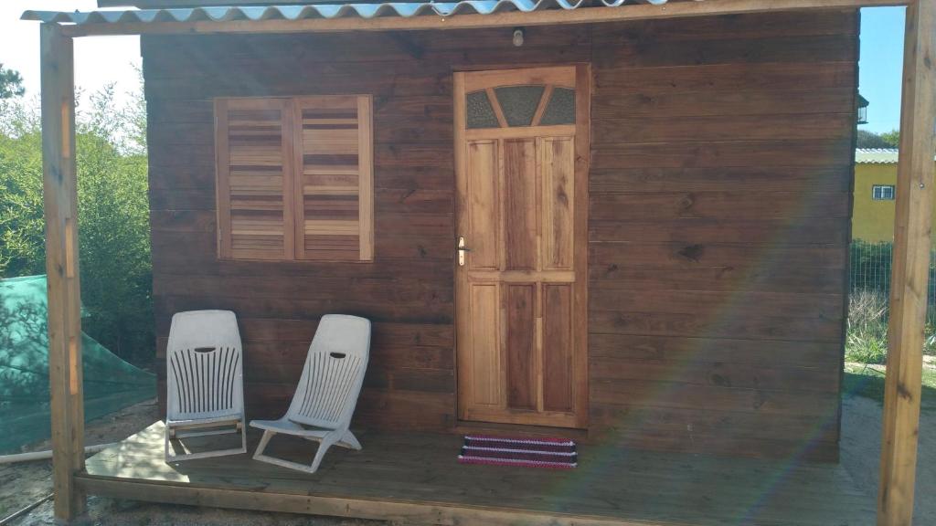 a small house with two chairs and a door at El Refugio in Santa Vitória do Palmar