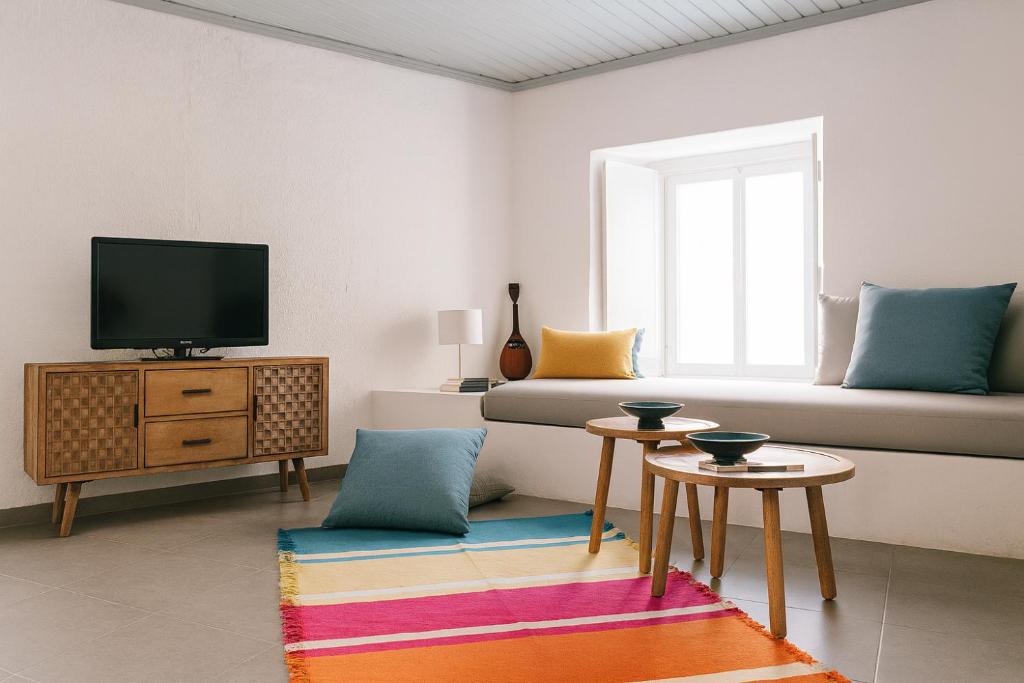 a living room with a tv and a couch at Keresbino Hydra Port House in Hydra