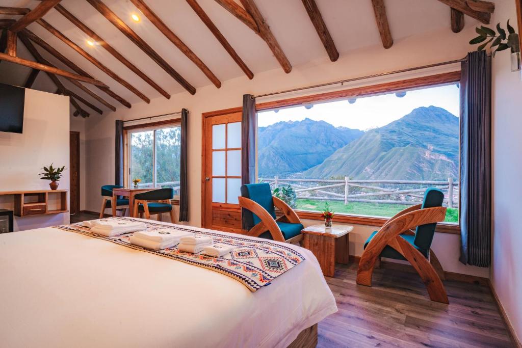 a bedroom with a bed and a large window at Tara Vegan Lodge - Sacred Valley in Urubamba