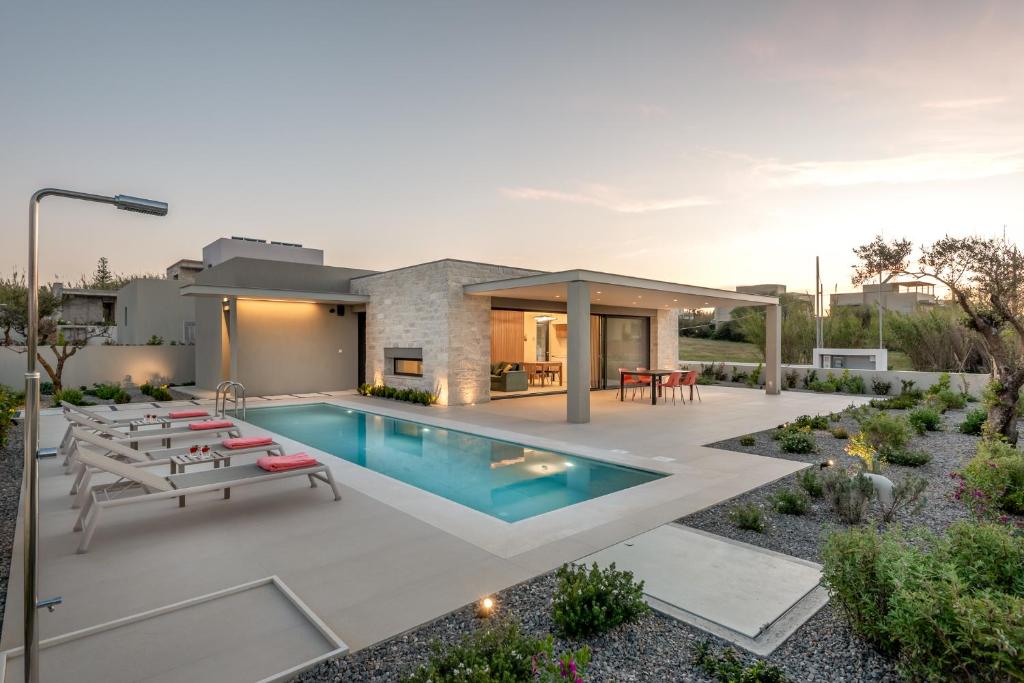 a backyard with a swimming pool and a house at Deux Olives Luxury Villa in Maleme